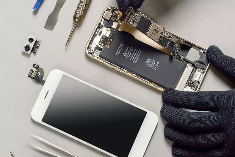 Geöffnetes Smartphone mit Reparaturwerkzeug auf der Werkbank